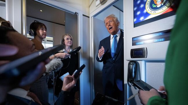 Президент США Дональд Трамп общается с журналистами на борту президентского самолета во время его перелета из Токио в Южную Корею