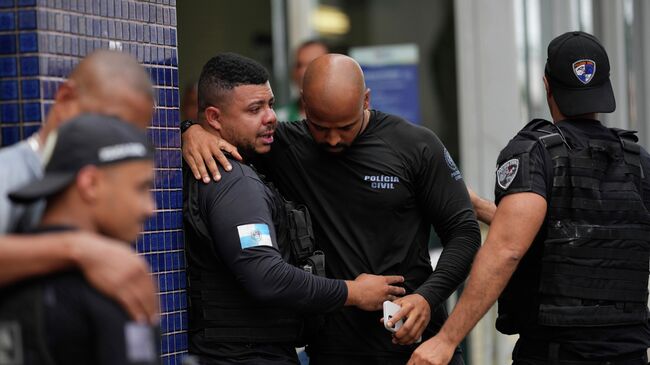 Полицейские у больницы имени Жетулиу Варгаса, куда доставили их коллегу, получившего ранение в ходе операции против предполагаемых наркоторговцев из банды Comando Vermelho. 28 октября 2025