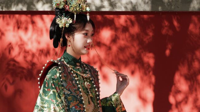 Девушка в национальном костюме на улице в Пекине Девушка в национальном костюме на улице в Пекине