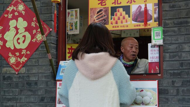 Девушка покупает еду в Пекине Девушка покупает еду в Пекине