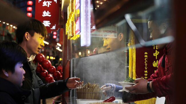 Посетители на рынке уличной еды Ванфуцзин в Пекине Посетители на рынке уличной еды Ванфуцзин в Пекине