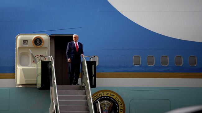 Президент США Дональд Трамп садится на борт самолета после двусторонней встречи с председателем КНР Си Цзиньпином