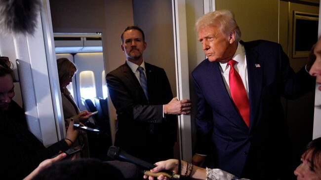 Президент США Дональд Трамп беседует с журналистами на борту Air Force One после встречи с председателем КНР Си Цзиньпином 