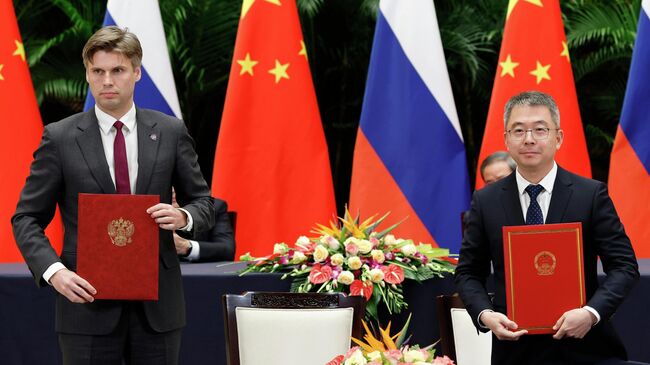 Генеральный директор госкорпорации Роскосмос Дмитрий Баканов и председатель Комиссии по китайской навигационной спутниковой системе Гуань Цзюнь на церемонии подписания российско-китайских документов по итогам 30-й регулярной встречи глав правительств РФ и КНР в Ханчжоу