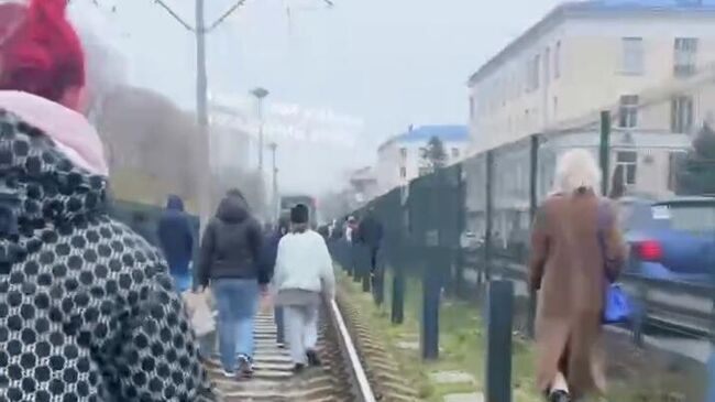 Люди идут по трамвайным путям в сторону района Борщаговки в Киеве