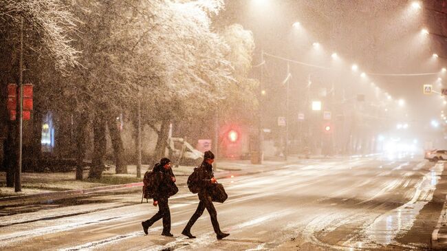 Прохожие во время первого снега в Москве