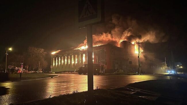 Сотрудники пожарной службы МЧС РФ тушат пожар в торговом центре Вокзальный после атаки беспилотниками ВСУ города Корочи