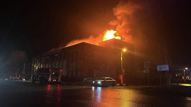 Сотрудники пожарной службы МЧС РФ тушат пожар в торговом центре Вокзальный после атаки беспилотниками ВСУ города Корочи