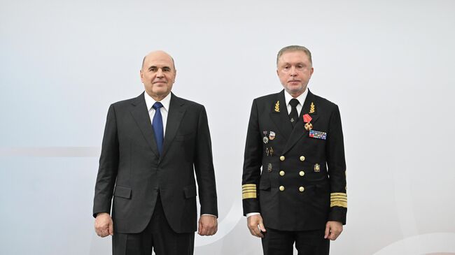 Председатель правительства РФ Михаил Мишустин и заместитель министра транспорта РФ Александр Пошивай, награжденный орденом Александра Невского, на выставке Транспорт России. 20 ноября 2025