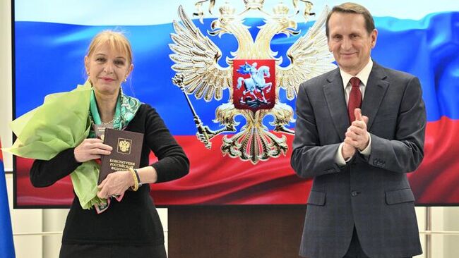 Директор Службы внешней разведки России Сергей Нарышкин и Изабель Пак во время вручения паспорта гражданина РФ