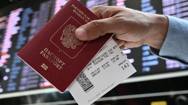 Пассажир держит в руках паспорт гражданина РФ и билеты в международном аэропорту Шереметьево
