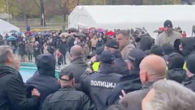 Стычка оппозиционных депутатов с обитателями палаточного городка перед началом заседания Скупщины (парламента) Сербии в Белграде. Кадр видео