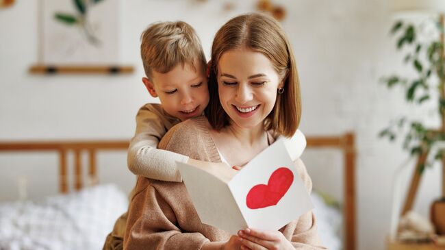 Ребенок дарит открытку на День матери