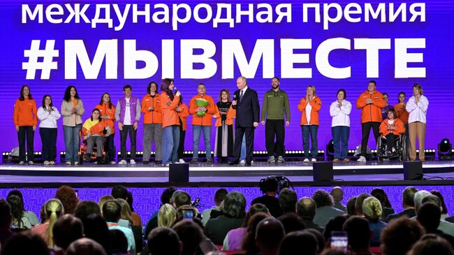 Президент РФ Владимир Путин и Анна Плужникова (восьмая слева), получившая награду в номинации Волонтер года, на церемонии награждения победителей международной премии #МЫВМЕСТЕ