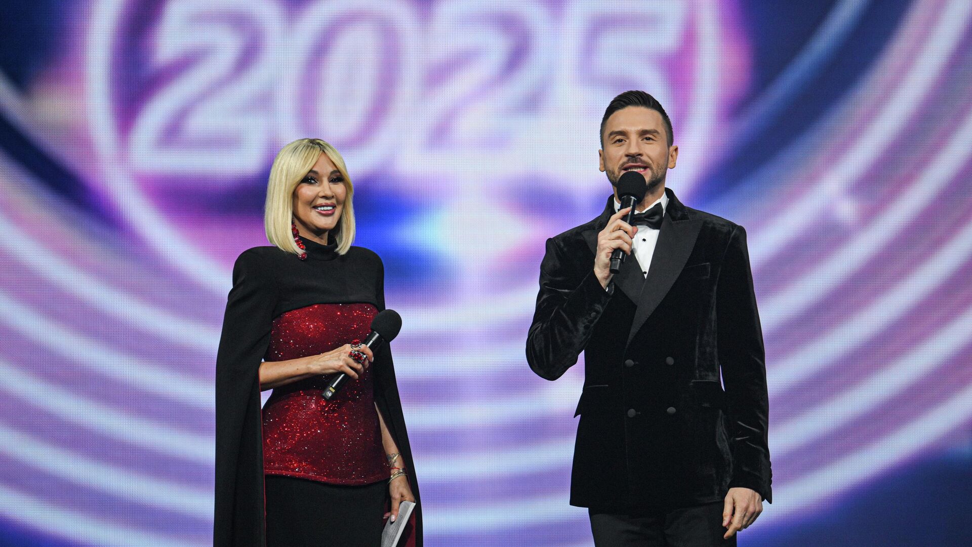 Ведущие Лера Кудрявцева и Сергей Лазарев выступают на концерте Песня Года 2025 в зале спортивного комплекса Мегаспорт в Москве - РИА Новости, 1920, 07.12.2025