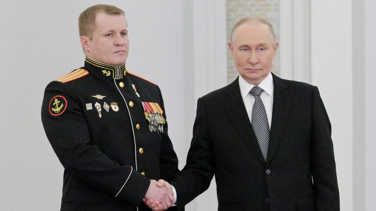 Президент РФ Владимир Путин вручает медаль Золотая Звезда Героя Российской Федерации майору Евгению Саввину на торжественном мероприятии по случаю празднования Дня Героев Отечества