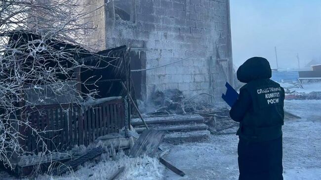 Сотрудник СК на месте пожара в селе Октемцы, Якутия