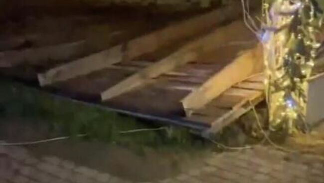 Последствия падения сорванной ветром крыши коммерческого здания в Каспийске