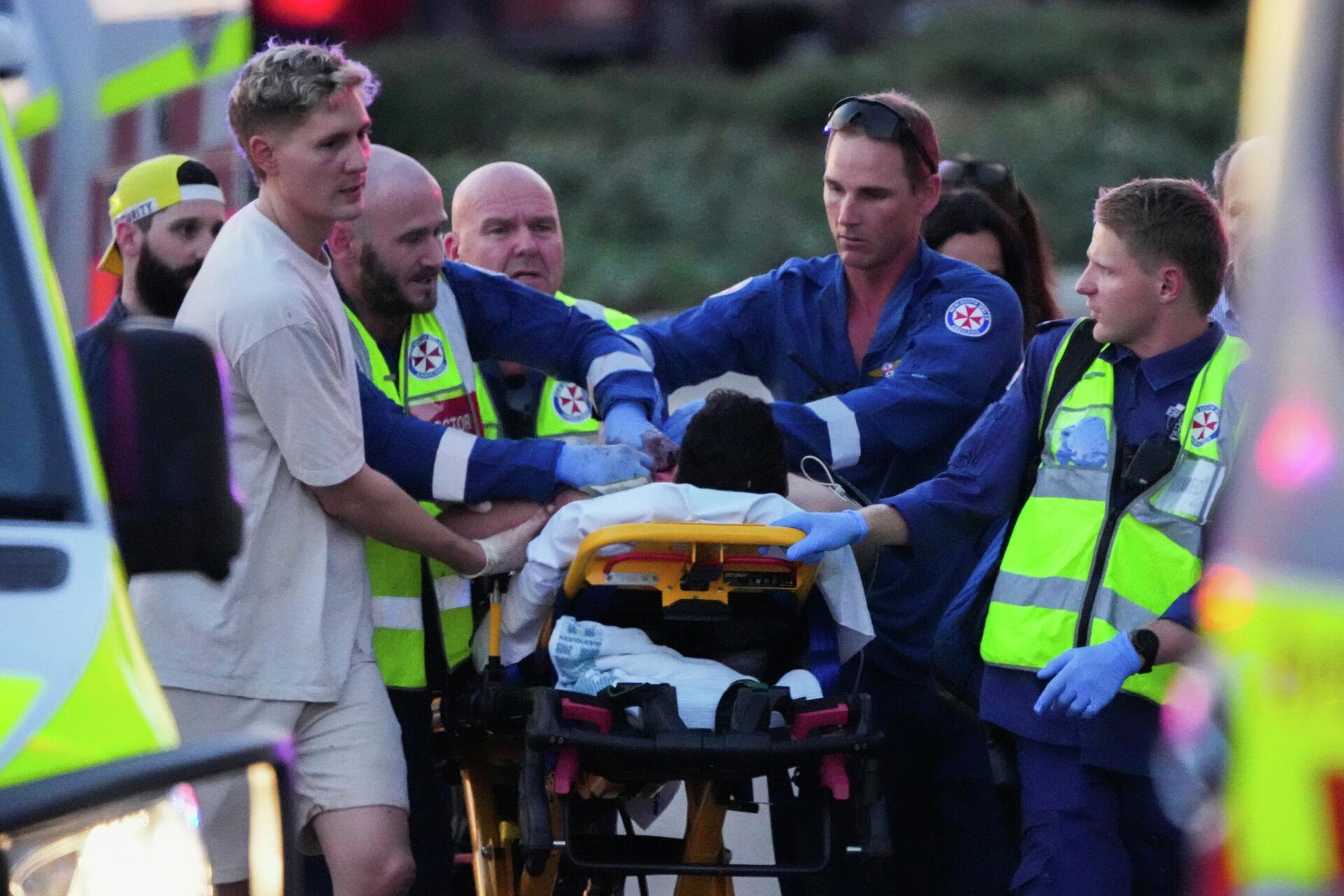 Сотрудники экстренных служб транспортируют раненного во время стрельбы на пляже Бондай в Сиднее Сотрудники экстренных служб транспортируют раненного во время стрельбы на пляже Бондай в Сиднее - РИА Новости, 1920, 15.12.2025