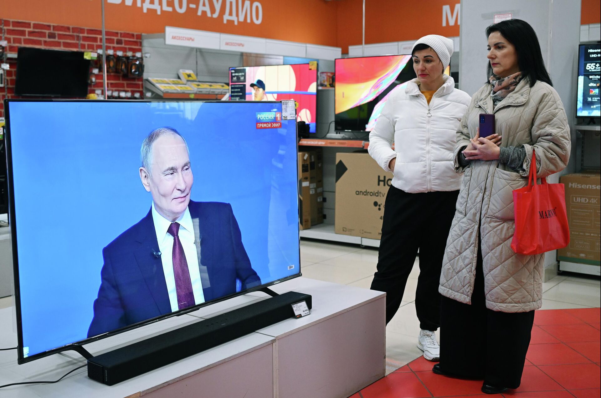 Женщины смотрят трансляцию специальной программы Итоги года с Владимиром Путиным в Симферополе