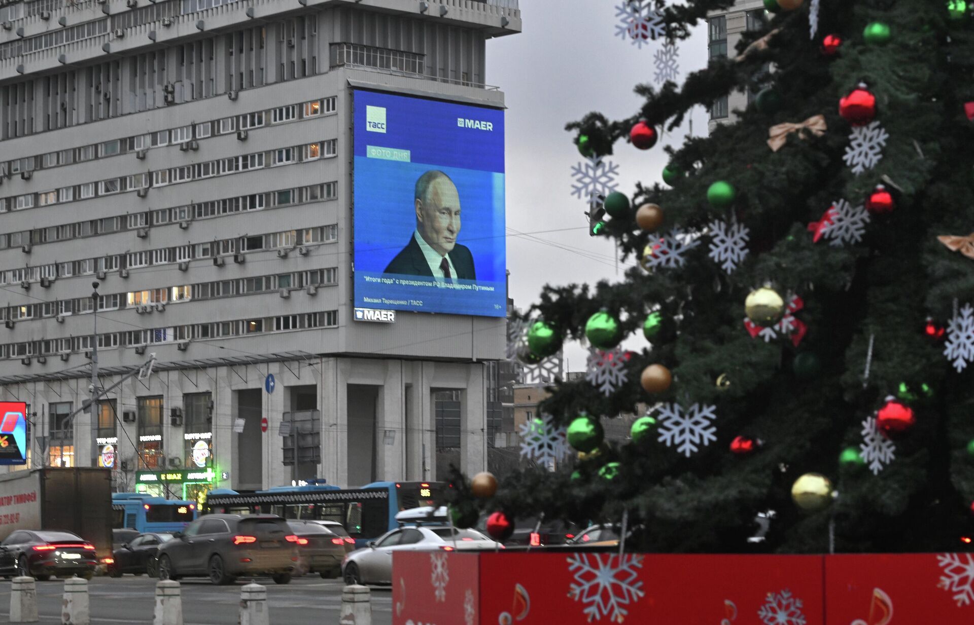 Кадры из специальной программы Итоги года с Владимиром Путиным транслируются на медиафасаде здания на Большой тульской улице в Москве