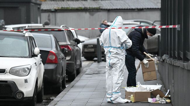 Сотрудники спецслужб работают на месте взрыва автомобиля Kia Sorento на парковке на улице Ясеневая в районе Орехово-Борисово