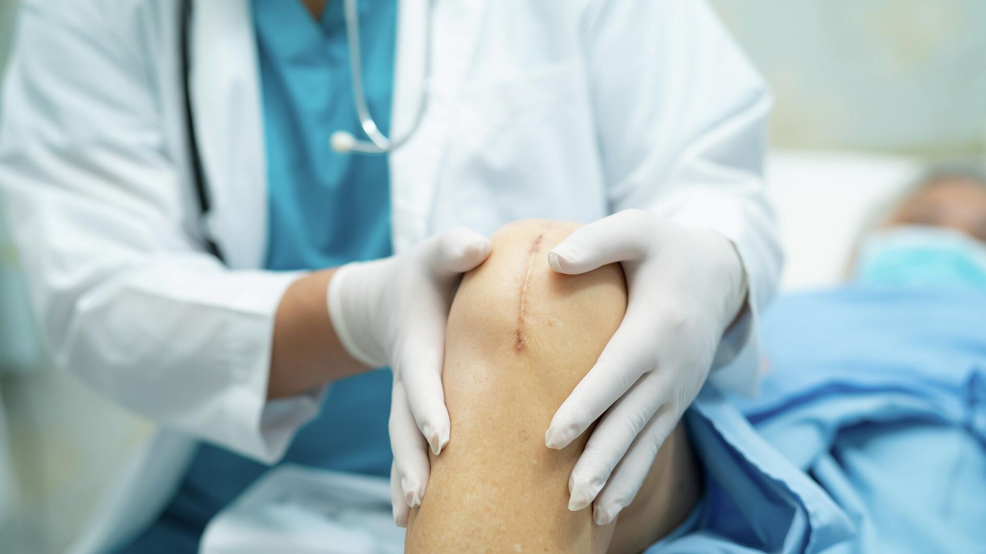 Врач осматривает пациента после операции по замене коленного сустава  - РИА Новости, 1920, 22.12.2025