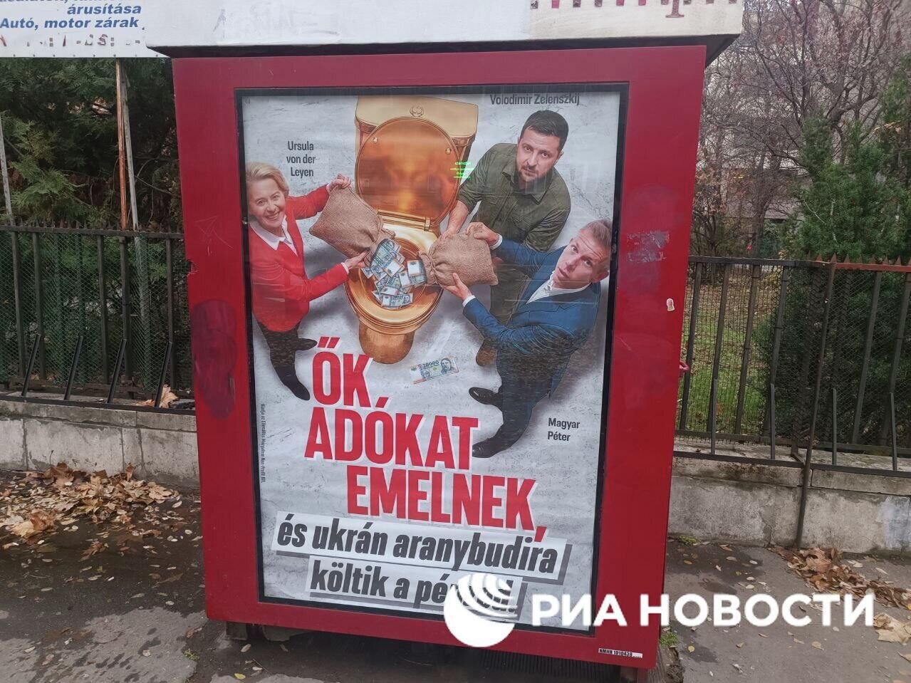 Плакат с изображением главы ЕК Урсулы фон дер Ляйен и Владимира Зеленского, которые сливают деньги в золотой унитаз - РИА Новости, 1920, 22.12.2025