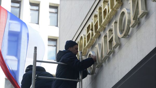 Рабочие устанавливают надпись Верховный Совет вместо демонтированной вывески с названием Верховная Рада на здание парламента Крыма