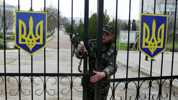 Солдат закрывает ворота на военно-воздушную базу Украины в Бельбеке