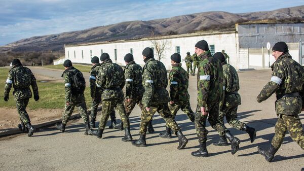 Украинские военные выходят с территории военной базы в поселке Перевальное.