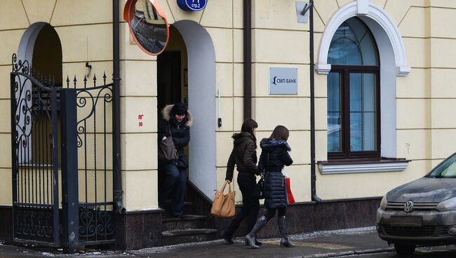 Женщина выходит из офиса СМП Банка на Садовнической улице в Москве, архивное фото