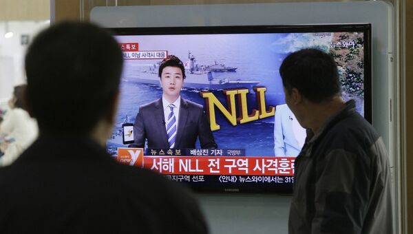Люди смотрят выпуск новостей в Сеуле. 31 марта 2014