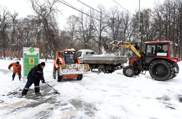 Сотрудники коммунальных служб убирают снег на улице