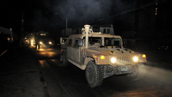 Военный конвой патрулирует дорогу в городе Икике после цунами