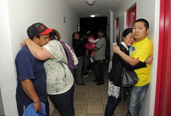 Жители чилийского города Икике собираются на верхнем этаже жилого дома в связи с угрозой цунами