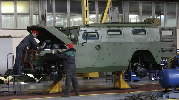 Рабочие осматривают военный бронеавтомобиль Тигр. Архивное фото