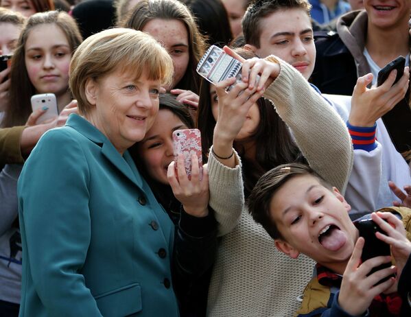 Школьники фотографируются вместе с Ангелой Меркель