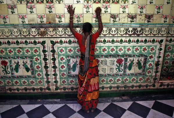 Женщина прикасается к стене храма во время фестиваля Навратри в Калькутте. 1 апреля 2014