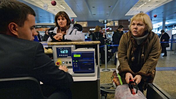 Пассажиры сдают багаж на стойке регистрации в аэропорту. Архивное фото