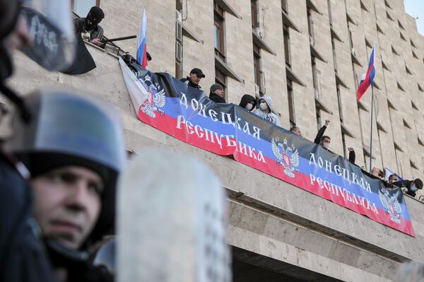 Участники митинга в Донецке, организованного сторонниками референдума о статусе региона, на здании областной администрации