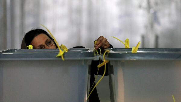Работница проверяет замок на избирательной урне во время выборов президента в Афганистане