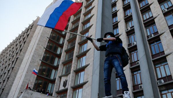 Активист с российским флагом у здания областной администрации в Донецке