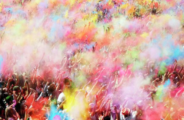 Люди бросают цветной порошок во время фестиваля Холи в Барселоне