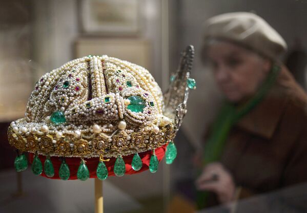 Посетительница рассматривает тюрбан-корону (Лакхнау, конец ХIХ в.) на выставке Индия: Драгоценности, покорившие мир в выставочном зале Успенской звонницы в Москве