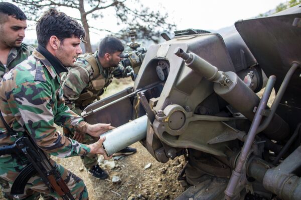 Артиллеристы сирийской армии заряжают орудие возле захваченного исламистами города Кесаб