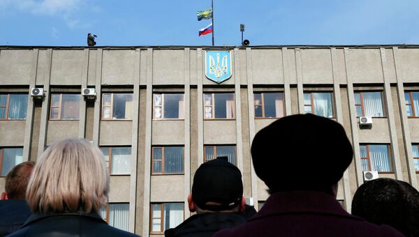 Сторонники федерализации Украины собрались перед зданием городской администрации Славянска, на крыше которого видны флаги России и Донецка