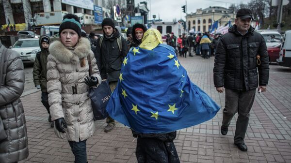 Женщина, обернувшаяся во флаг ЕС, идет по Крещатику в Киеве.