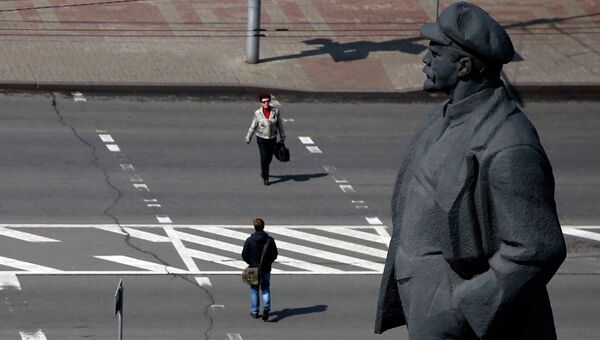 Люди переходят улицу у памятника Владимиру Ленину в Донецке. Архивное фото