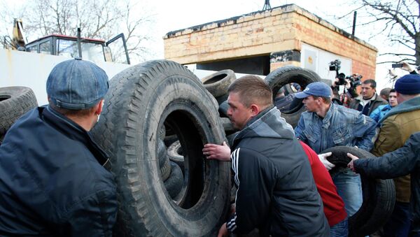 Сторонники федерализации Украины строят баррикаду из покрышек около ворот аэропорта Краматорска